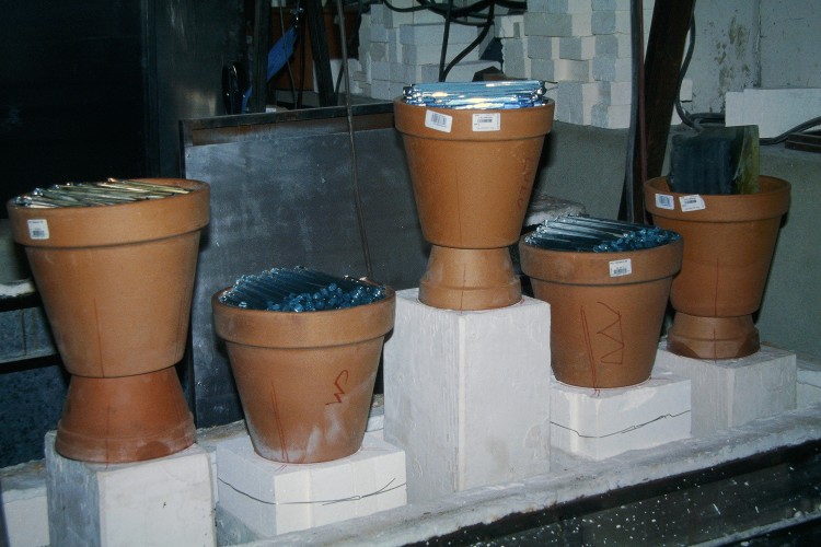 Verre-en-Forme à Montoison (26) par Frédéric Morin et Salomé : un four chargé de cinq moules, leurs rechausses et leurs pots-de-fleurs remplis de verre optique, avant mise en place du deuxième étage du four