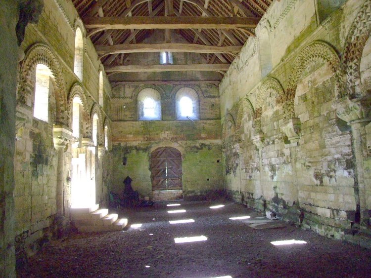 paroissiale Saint-Pierre de Thaon (14) la nef charpentée vue vers le portail occidental du milieu du XIIe siècle, avec ses grandes arcades ornées de zigzags