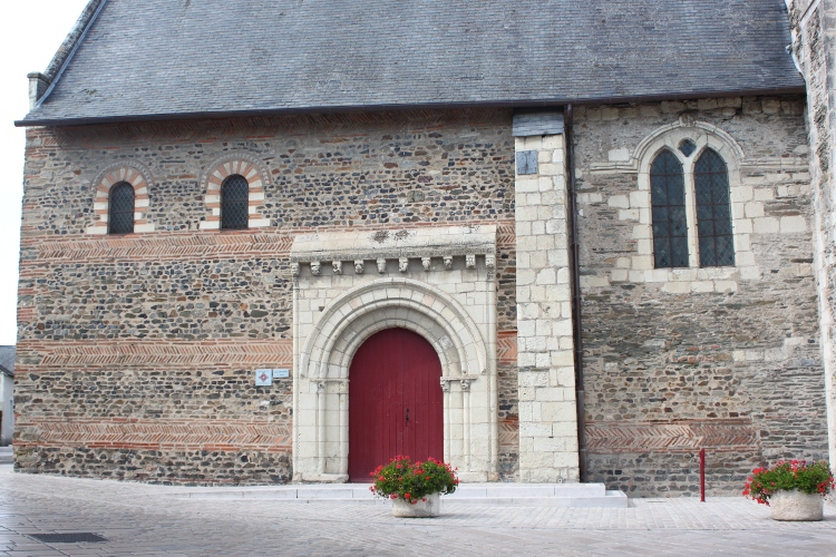 Savennières (49) église St-Pierre et St-Romain : façade sud - le portail sud est roman, aménagé dans les maçonneries carolingiennes en arêtes de poisson de briques rouges et fenêtres hautes bicolores