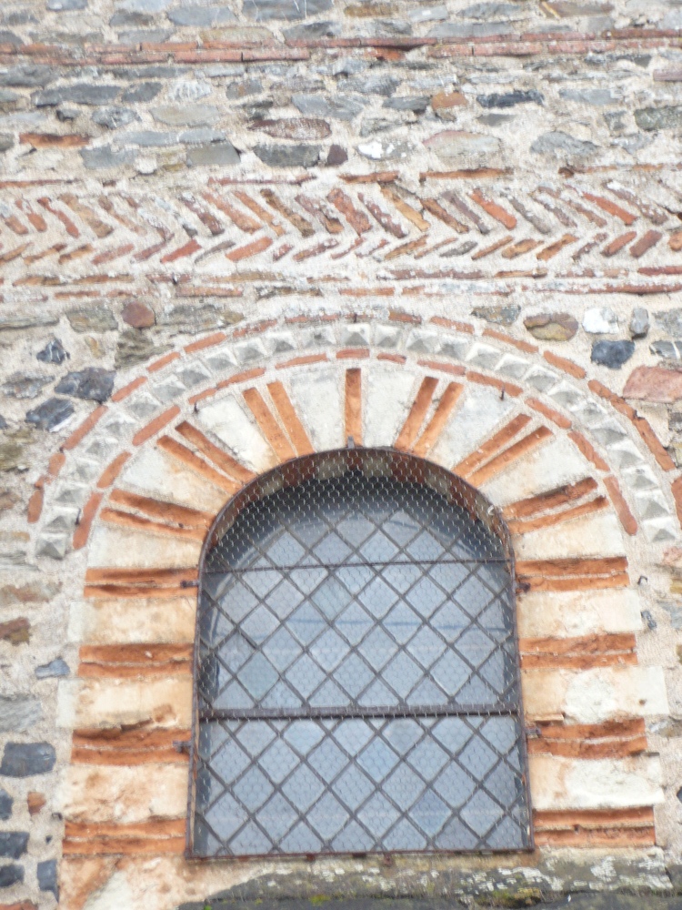 Savennières (49) église St-Pierre et St-Romain : façade ouest - détail d'appareillage bicolore de l'une des fenêtres hautes de 913 et arêtes de poisson de brique au-dessus du portail